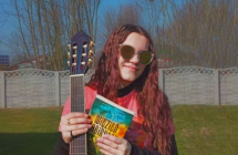 Dziewczynka z gitara i ksiazka  na tle drzew