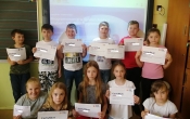 1.- uczniowie z certryfikatami przed tablica ze strona glowna portalu edukacyjnego