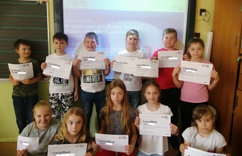 1.- uczniowie z certryfikatami przed tablica ze strona glowna portalu edukacyjnego