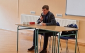 adwokat za stolem podczas spotkania z uczniami
