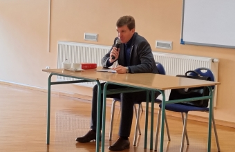 adwokat za stolem podczas spotkania z uczniami