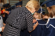 Dzieci otrzymuja tarcze szkolne z rak dyrekcji