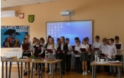 zbiorowe zdjecie uczniow klasy 4 na tle dekoracji