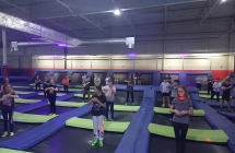uczniowie podczas rozgrzewki w parku trampolin